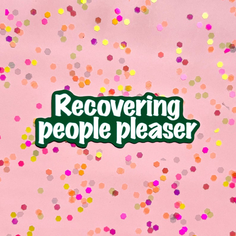 May include: Green sticker with white text that reads "recovering people pleaser" on a pink background with colorful glitter.