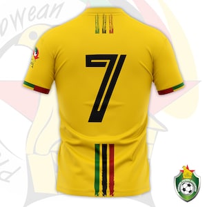 May include: A yellow soccer jersey with the number 7 in black on the back. The jersey has green, black, and red stripes on the back and shoulders, and the Zimbabwe Football Association logo on the sleeve.