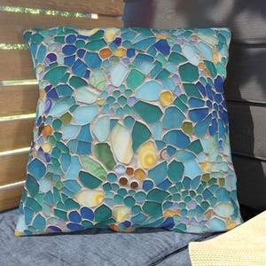 May include: A square throw pillow featuring a vibrant mosaic pattern of interlocking glass-like shapes in various shades of blue, teal, turquoise, and yellow. The design mimics a stained glass or sea glass arrangement with distinct white grout lines.