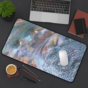 May include: A blue and green iridescent mouse mat with a white computer mouse on top. The mouse mat has a textured surface that resembles a seashell.