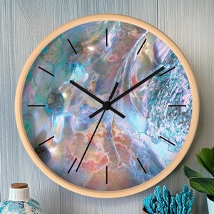 Könnte beinhalten: Eine runde Wanduhr mit einem Holzrahmen und einem farbenfrohen, schillernden Perlmutt-Design. Das Zifferblatt der Uhr hat schwarze Zeiger und schwarze römische Ziffern.