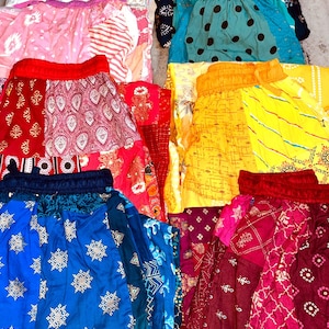 Pode incluir: Uma coleção de seis calças com cintura elástica apresentando vários padrões coloridos, incluindo desenhos florais, geométricos e de bolinhas em tons de azul, vermelho, rosa, amarelo e verde-azulado, dispostos em uma grade.