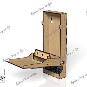 May include: A wooden dice tower with a hinged lid and a tray that flips out to catch the dice. The tower is made of light brown wood and has a small hole in the top for rolling the dice. The tray is also made of wood and has a dark blue felt lining.