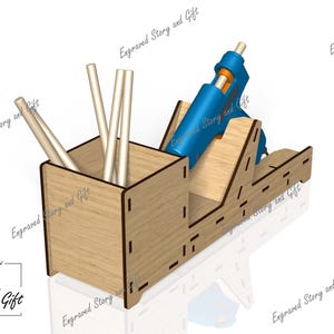 K&ouml;nnte beinhalten: Ein Holzorganizer mit einem Fach f&uuml;r Klebesticks und einem Halter f&uuml;r eine blaue Hei&szlig;klebepistole. Der Organizer ist aus Holz und hat eine nat&uuml;rliche Oberfl&auml;che.