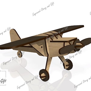 Puede incluir: Un modelo de avión de madera con un cuerpo marrón claro y alas y hélice marrón oscuro. El avión tiene tres ruedas y está diseñado con líneas de corte visibles. El texto "Story & Gift" está en la esquina inferior izquierda.