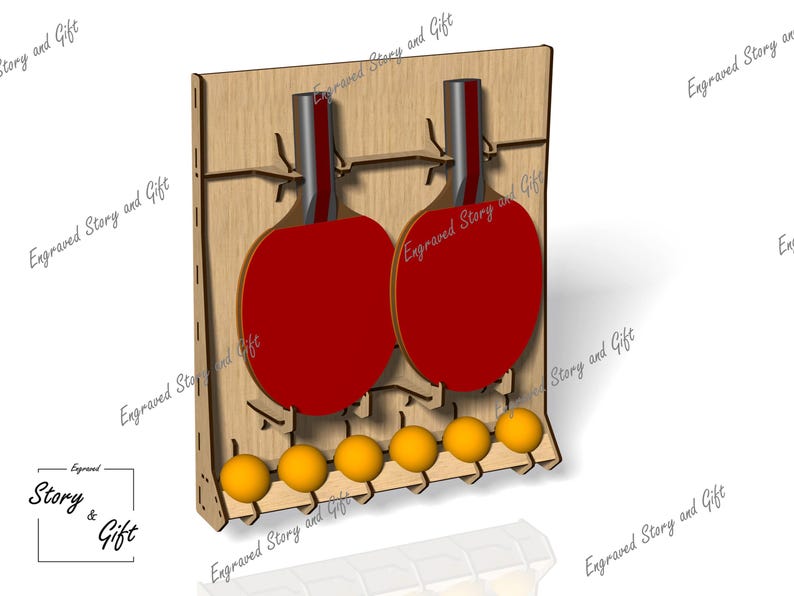 May include: Wooden ping pong paddle and ball holder. The holder is made of light brown wood and features two red paddles and six yellow balls. The text "Engraved Story and Gift" is visible.