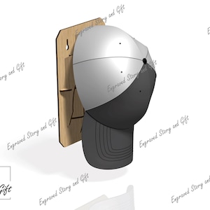 May include: A baseball cap displayed on a wooden wall mount. The cap is two-toned, with a grey crown and a dark grey bill. The wooden mount has a keyhole for hanging. The words "Engraved Story and Gift" are printed on the image.