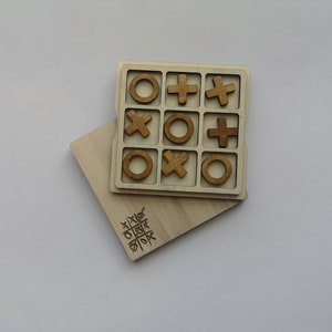 Op de afbeelding: Een houten tic-tac-toe spel met bruine houten stukken in de vorm van X en O. Het spel is op een houten bord met een rasterpatroon.