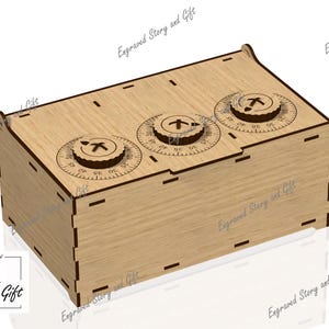 May include: A wooden box with three combination dials. The dials are circular with numbers and symbols. The box is made of light-colored wood and has a rectangular shape. The text "Story & Gift" is in the lower left corner.