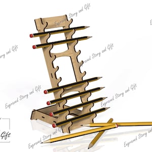 May include: A wooden pencil holder with multiple slots, holding several yellow and black pencils with red erasers. The holder has a unique design and the text "Engraved Story and Gift" is visible. Some pencils are lying on the surface.
