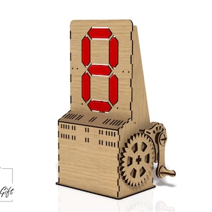 Może przedstawiać: Drewniany zegar cyfrowy z czerwoną cyfrą osiem. Zegar posiada przekładnię zębatą i korbę. Zbudowany z jasnego drewna, zegar ma nowoczesny design. Zegar ma około 15 cm wysokości.