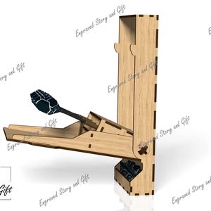 May include: A wooden dice tower with a hinged door that opens to reveal a compartment for dice. The tower is made of light brown wood and has a dark brown stain. The tower is designed to hold dice and allow them to be rolled out of the top.