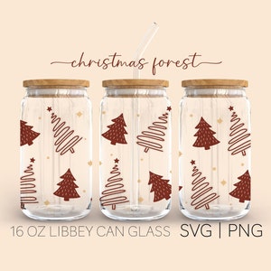 May include: Three 16 ounce glass jars with wooden lids and red and gold Christmas tree designs. The text "christmas forest" is written above the jars. The text "16 OZ LIBBEY CAN GLASS SVG | PNG" is written below the jars.