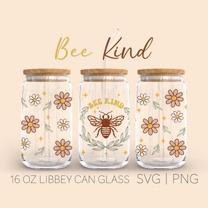 Può includere: Tre bicchieri trasparenti a forma di lattina con coperchi in legno e una cannuccia. I bicchieri presentano disegni floreali e di api con le parole "Bee Kind". Ogni bicchiere è da 473 ml.
