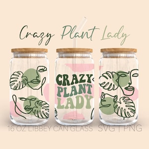 May include: Three 16 ounce glass jars with wooden lids and green straws. The jars are decorated with a pink and green pattern of abstract faces, leaves, and the text "Crazy Plant Lady".
