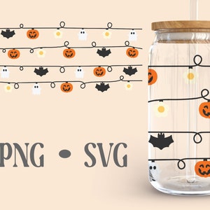 Puede incluir: Un vaso de vidrio transparente con tapa de madera y una pajita. El vaso tiene un dise&ntilde;o de tem&aacute;tica de Halloween con una cadena de luces con fantasmas, murci&eacute;lagos y calabazas.