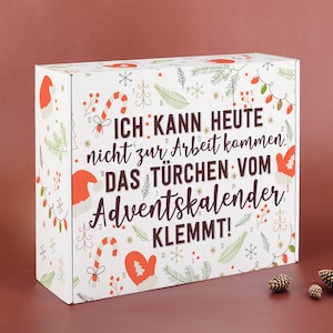 Può includere: Una scatola rettangolare bianca per calendario dell'avvento con il testo in tedesco ICH KANN HEUTE nicht zur Arbeit kommen, DAS TÜRCHEN VOM Adventskalender KLEMMT! La scatola è decorata con illustrazioni natalizie rosse e verdi, tra cui bastoncini di zucchero, muffole e rami di pino.