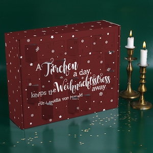 Può includere: Un calendario dell'avvento rosso con un motivo a stella bianca e il testo "A Tirchen a day, keeps the Weihnachtsstress away. Für Claudia von Harald".