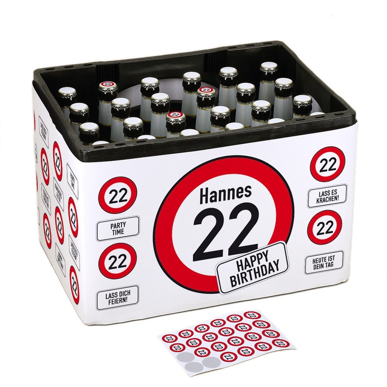 May include: A white cardboard box with a red and white speed limit sign design. The sign says "Hannes 22 Happy Birthday". The box is filled with 22 bottles of beer. There are also 22 small stickers with the number 22 on them.