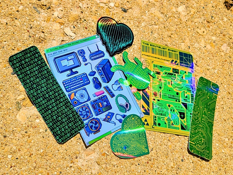 May include: A collection of colorful stickers with tech-themed designs. Includes a binary code strip, a computer parts sheet, and circuit board shapes. The stickers feature shades of green, blue, and yellow, with some holographic elements.