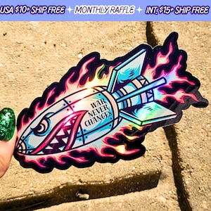 May include: A holographic sticker of a rocket with flames, a toothy grin, and the text "WAR NEVER CHANGES".
