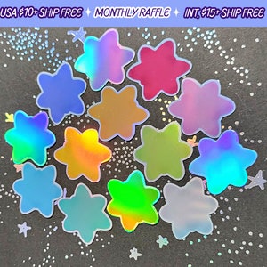 May include: A collection of iridescent star-shaped stickers in various colors, including blue, pink, and gold. The stickers have a holographic effect, reflecting multiple colors. The background is dark with scattered star-shaped confetti.