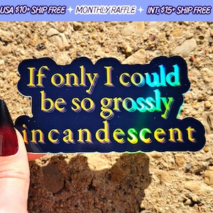 May include: A holographic sticker with the text "If only I could be so grossly incandescent" in yellow and blue. The sticker has a dark blue background and is held against a textured, light brown surface.