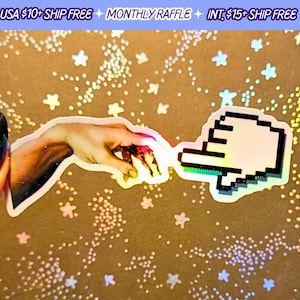 May include: Two stickers: one showing a hand reaching out, the other a pixelated hand cursor. They are on a gold background with star and dot patterns. The text "USA $10+ SHIP FREE MONTHLY RAFFLE INT. $15+ SHIP FREE" is at the top.