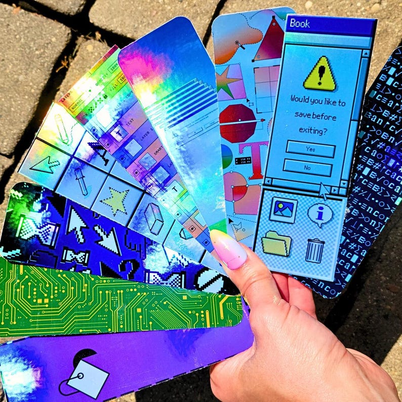 May include: A collection of colorful, holographic bookmarks. Designs include computer interface graphics, circuit board patterns, and geometric shapes. One bookmark features the text "Book" and a prompt: "Would you like to save before exiting?"