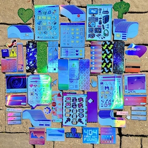 May include: A collection of colorful stickers with a retro computer interface theme. Designs include computer screens, error messages, and pixelated graphics in shades of blue, pink, green, and purple. Some stickers have text.
