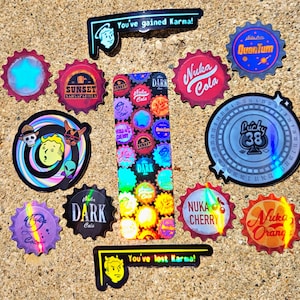 May include: A collection of colorful, holographic stickers with various designs and text. The stickers feature bottle cap shapes with text like "Nuka Cola," "Sunset Sarsaparilla," and "Lucky 38." Other stickers have cartoon characters and the phrases "You've gained Karma!" and "You've lost Karma!"