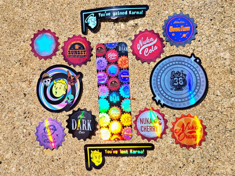 May include: A collection of colorful, holographic stickers with various designs and text. The stickers feature bottle cap shapes with text like "Nuka Cola," "Sunset Sarsaparilla," and "Lucky 38." Other stickers have cartoon characters and the phrases "You've gained Karma!" and "You've lost Karma!"