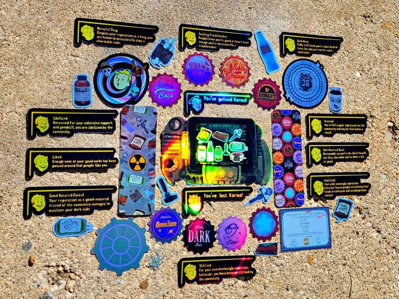 May include: A collection of Fallout-themed stickers and a Pip-Boy prop are arranged on a textured surface. The stickers feature various designs, including bottle caps, logos, and text. The Pip-Boy is a handheld device with a screen and buttons.