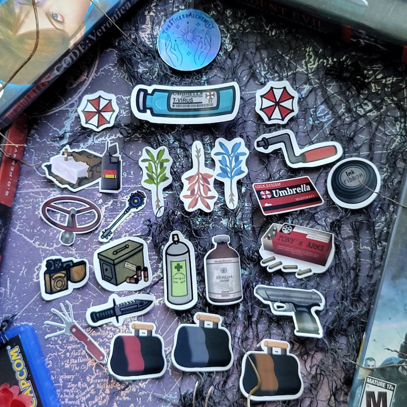 May include: A collection of stickers featuring various designs. Includes stickers of a T-Virus vial, Umbrella Corporation logos, a key, a gun, and other themed graphics. The stickers are colorful and detailed, with some featuring text.