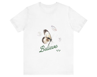 Könnte beinhalten: Weißes T-Shirt mit einem grünen Schmetterlingsmotiv und dem Wort "Believe" in grüner Schrift.