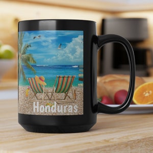 May include: Black ceramic coffee mug with a beach scene featuring two lounge chairs, a palm tree, and the word "Honduras".