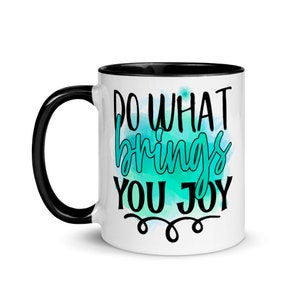 May include: White ceramic coffee mug with a black rim and handle. The mug features a teal watercolor background with the text "Do what brings you joy" in black.