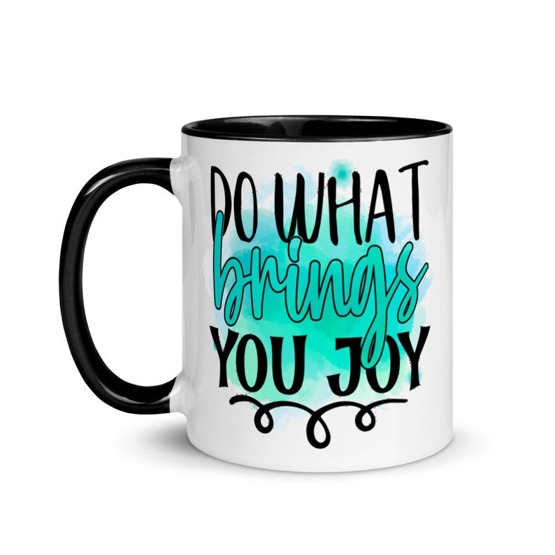 May include: White ceramic coffee mug with a black rim and handle. The mug features a teal watercolor background with the text "Do what brings you joy" in black.