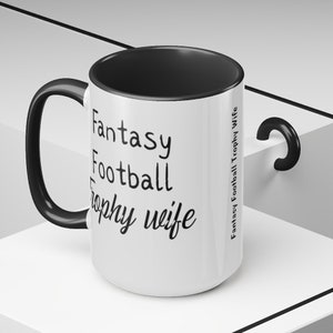 May include: White ceramic mug with a black handle and black rim. The mug has black text that reads "Fantasy Football Trophy Wife".
