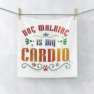 Könnte beinhalten: Weißes Küchentuch mit dem Text "Dog Walking is my Cardio" in Regenbogen-Glitzerbuchstaben mit Pfotenabdrücken und Schnörkeln.