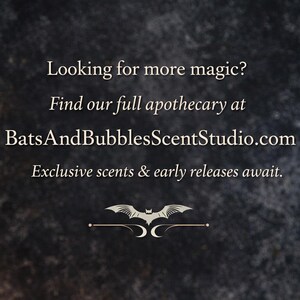 May include: A dark, textured background featuring white text that reads: Looking for more magic? Find our full apothecary at BatsAndBubblesScentStudio.com. Exclusive scents & early releases await. Below the text is a small white bat graphic.