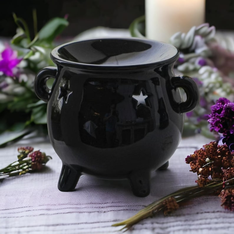 A magical Cauldron Wax Warmer and Oil Burner, perfect for adding a witchy touch to any space. The cauldron design holds your favorite wax melt or essential oil, while a tealight beneath gently warms and releases enchanting, aromatic scents. Ideal for creating a mystical, spellbinding atmosphere in your home.