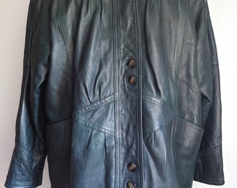 May include: A dark green leather jacket with a high collar and button closure. The jacket has a fitted silhouette and a slightly longer length.