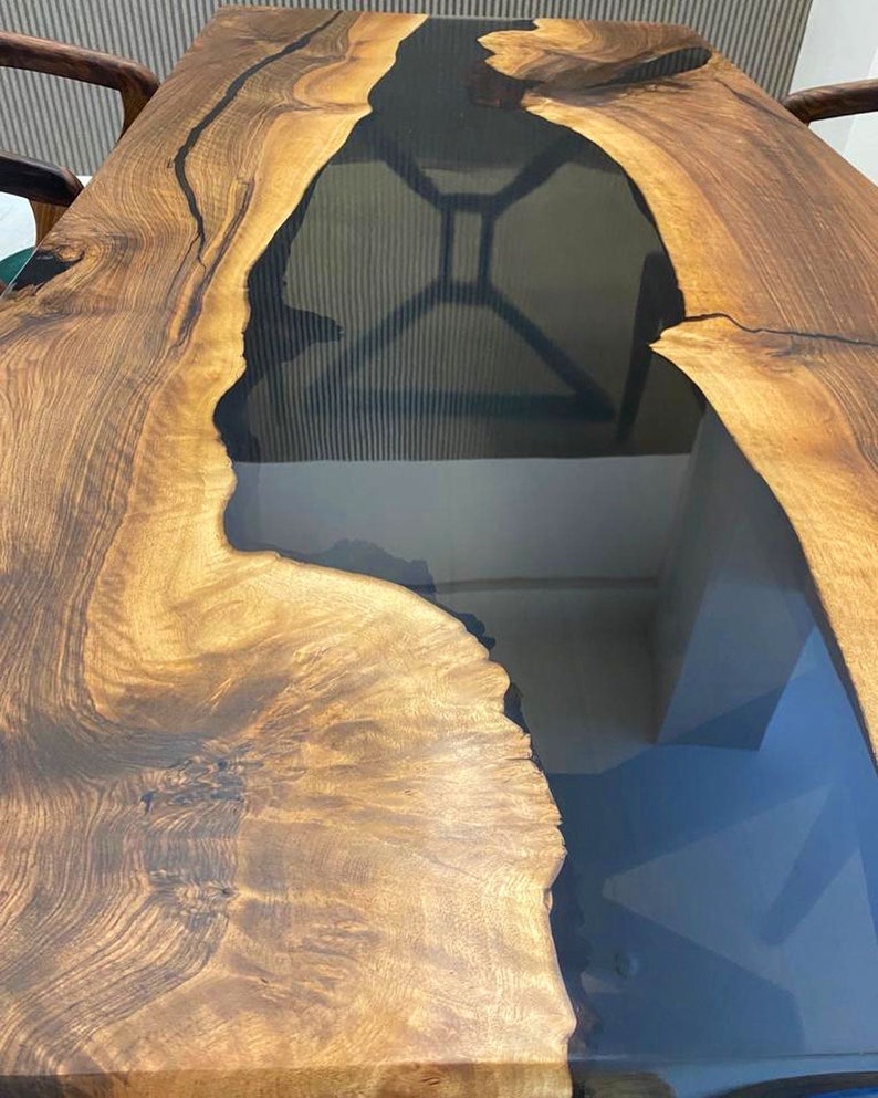 K&ouml;nnte beinhalten: Eine Tischplatte aus Holz mit einer nat&uuml;rlichen Holzmaserung und einem schwarzen Epoxidharzfluss, der durch die Mitte verl&auml;uft.