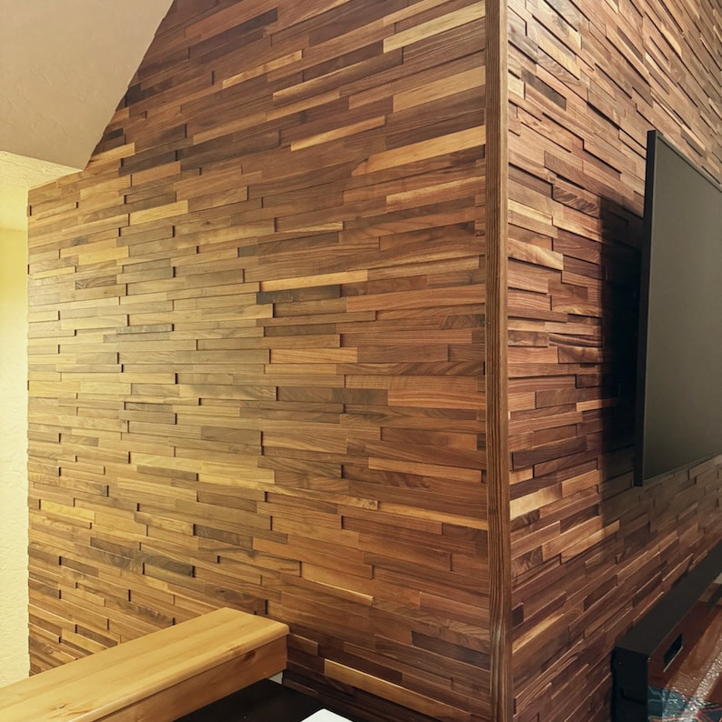 Pu&ograve; includere: Una parete rivestita con un rivestimento in legno composto da sottili pezzi rettangolari di legno in diverse tonalit&agrave; di marrone. Il legno &egrave; disposto a spina di pesce, creando una superficie testurizzata e visivamente interessante.