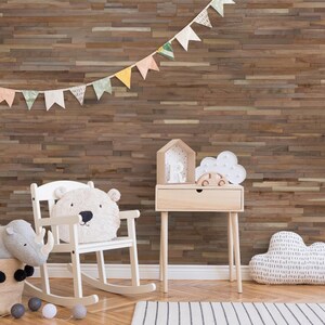 Pu&ograve; includere: Un muro in legno marrone chiaro con una sedia a dondolo bianca, un comodino bianco e un rinoceronte di peluche grigio. Il muro &egrave; decorato con una fila di bandierine colorate.