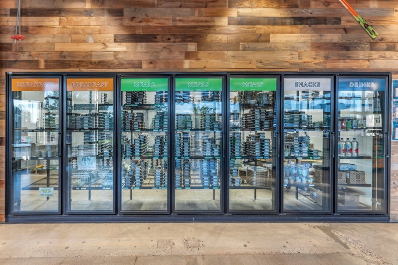 May include: Six glass-door refrigerators with black frames, labeled "Breakfast", "Meals", "Snacks", and "Drinks". The refrigerators are filled with various food and beverage items.