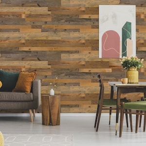 May include: A living room with a brown sofa, a wooden side table, and a dining table with four chairs. The walls are covered in reclaimed wood panels. There is a painting on the wall with abstract shapes in pink and green.