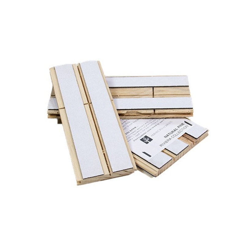 May include: Three pieces of natural pine wood wall paneling with adhesive backing. The wood is light brown and the adhesive is white. The packaging label reads "Natural Pine Riviera Collection".