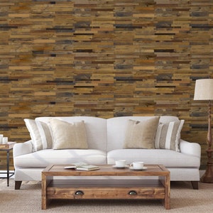 May include: A white sofa with pillows sits in front of a wall covered in reclaimed wood panels. A wooden coffee table sits in front of the sofa, and two white armchairs are on either side of the sofa. A floor lamp with a white lampshade is in the corner of the room.